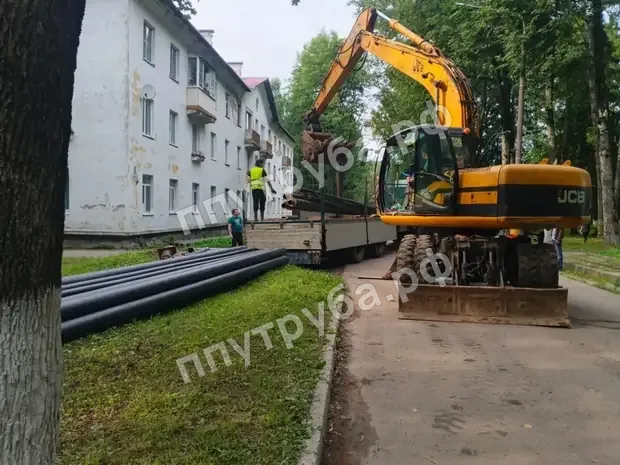 Разгрузка труб ППУ экскаватором на объекте